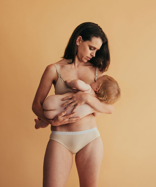 Postpartum mother breastfeeding her baby. Mom nursing baby.